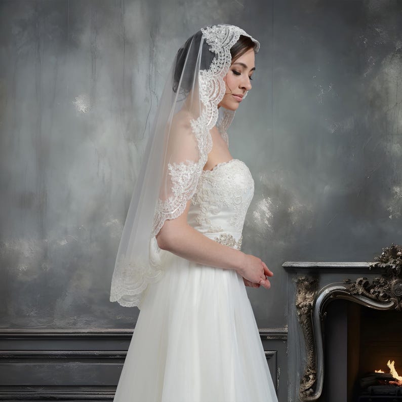 Pode incluir: Um v&eacute;u de noiva branco com uma delicada renda. O v&eacute;u &eacute; usado por uma pessoa com um vestido de noiva branco.
