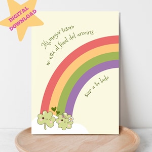 May include: A printable digital download of a motivational quote in Spanish. The quote reads "Mi mayor tesoro no está al final del arcoiris, Sino a tu lado." The quote is written in a cursive font and is accompanied by a rainbow and two cartoon shamrocks with hearts.