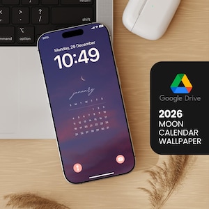 Può includere: Uno smartphone mostra uno sfondo del calendario lunare di gennaio 2026 su uno sfondo sfumato viola e blu. Il telefono è su una superficie di legno accanto a un laptop e a un'icona di Google Drive con il testo "2026 Moon Calendar Wallpaper."