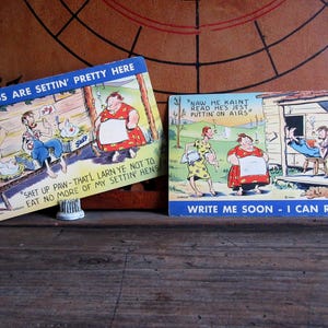 May include: A set of three ceramic mugs with a speckled, matte finish. The mugs are in shades of cream, light gray, and dark gray. Each mug has a simple, minimalist design and a rounded handle. The mugs are likely for coffee or tea.