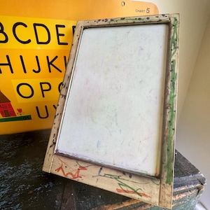 May include: A vintage wooden framed chalkboard with colorful chalk marks. The frame is painted with green and red accents. A yellow chart with the alphabet is visible in the background.