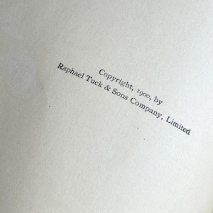Pode incluir: Um close-up de uma p&aacute;gina com texto. O texto diz "Copyright, 1900, by Raphael Tuck & Sons Company, Limited" em uma fonte cinza escuro. O papel tem uma apar&ecirc;ncia ligeiramente texturizada e esbranqui&ccedil;ada.
