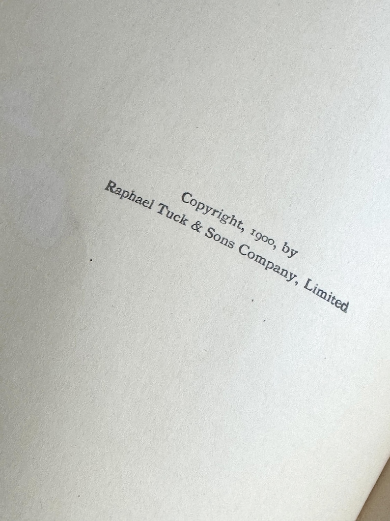 Pode incluir: Um close-up de uma p&aacute;gina com texto. O texto diz "Copyright, 1900, by Raphael Tuck & Sons Company, Limited" em uma fonte cinza escuro. O papel tem uma apar&ecirc;ncia ligeiramente texturizada e esbranqui&ccedil;ada.