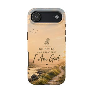 May include: A phone case featuring a scenic landscape with a river, path, and sunset. The case has the text "BE STILL AND KNOW THAT I AM GOD" and "PSALM 46:10". The case is designed to fit a phone.