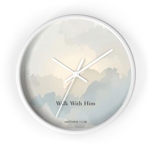 Könnte beinhalten: Weiße Wanduhr mit einem Design eines bewölkten Himmels in Blau-, Beige- und Weißtönen. Das Zifferblatt zeigt den Text "Walk With Him" und die Referenz "Matthew 11:28". Die Uhrzeiger sind weiß.