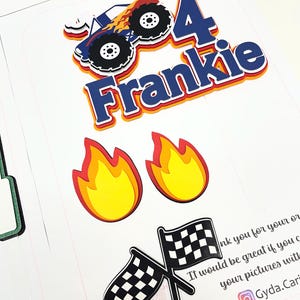 May include: A layered paper cake topper set featuring a blue monster truck with orange flames, the number 4, and the name Frankie in blue letters. The set includes two yellow and red flame cutouts and two crossed black and white checkered flags.