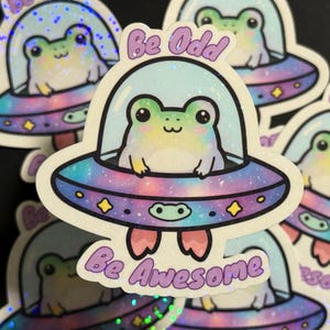 Sticker Be Odd Be Awesome – Sticker grenouille dans un vaisseau spatial – Sticker holographique fantaisiste – Sticker grenouille de l'espace pour ordinateur portable – Sticker original mignon