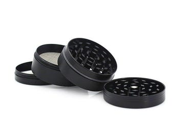 May include: Four piece black metal grinder with a screen. The grinder has a textured surface and is designed for grinding herbs.
