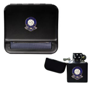 May include: Black rolling tobacco case with a Chelsea Football Club logo. The case has a built-in rolling tray and a lighter with the same logo.