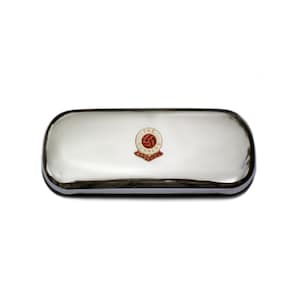 May include: A silver-colored rectangular case with rounded edges. The case features a red and white emblem with the text "THE GUNNERS ARSENAL" in a circular design. The case has a reflective surface.