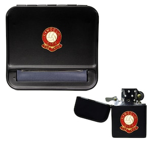 May include: Black rolling tobacco case and lighter with a red and gold Lincoln City Football Club logo. The logo features a white soccer ball.