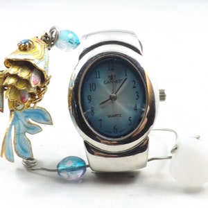 Miniature table clock to please rodeo lover or ranch person watchface. featuring a charm of a horse within a spur on a silver e.g.o