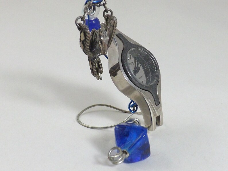 Miniature table clock to please rodeo lover or ranch person watchface. featuring a charm of a horse within a spur on a silver e.g.o