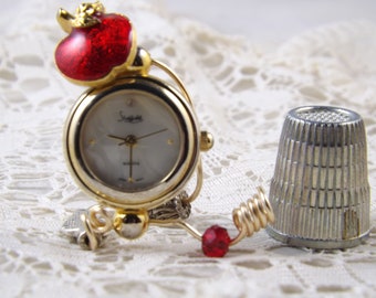 MIniature table clock made from round repurposed watch face of gold and white with red apple, visions of Snow White or treat for a teacher.