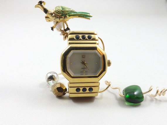 Miniature table clock to please rodeo lover or ranch person watchface. featuring a charm of a horse within a spur on a silver e.g.o