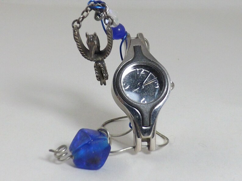 Miniature table clock to please rodeo lover or ranch person watchface. featuring a charm of a horse within a spur on a silver e.g.o