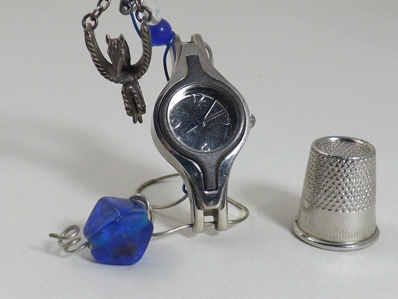 Miniature table clock to please rodeo lover or ranch person watchface. featuring a charm of a horse within a spur on a silver e.g.o