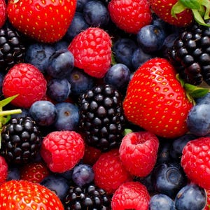 May include: A close-up shot of a mix of fresh berries. Bright red strawberries, raspberries, and blackberries are scattered among deep blue blueberries. The berries are ripe and juicy, with a variety of textures and shapes.