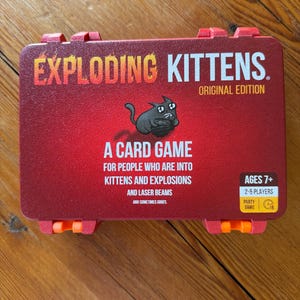 Custom 3D-printed storage box for Exploding Kittens. Holds cards securely with a built-in divider, doubles as a deck and discard holder. UV-printed artwork ensures crisp, vibrant designs. Perfect for organising and upgrading your game night setup.