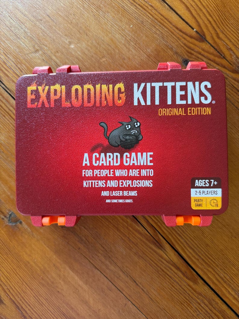 Custom 3D-printed storage box for Exploding Kittens. Holds cards securely with a built-in divider, doubles as a deck and discard holder. UV-printed artwork ensures crisp, vibrant designs. Perfect for organising and upgrading your game night setup.