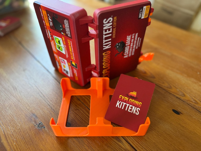 Custom 3D-printed storage box for Exploding Kittens. Holds cards securely with a built-in divider, doubles as a deck and discard holder. UV-printed artwork ensures crisp, vibrant designs. Perfect for organising and upgrading your game night setup.