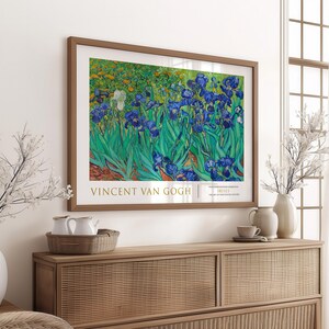 May include: A framed print of a painting by Vincent van Gogh featuring a field of blue irises with green leaves. The title of the painting is "Irises" and the artist's name is "Vincent van Gogh".
