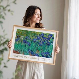 May include: A framed print of Vincent van Gogh's Irises painting. The painting features a field of blue irises with green leaves against a yellow and green background. The frame is made of wood and has a gold trim.