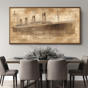 May include: A sepia-toned blueprint style illustration of the RMS Titanic, a large passenger liner, with detailed drawings of the ship's interior and exterior. The image is framed in a brown wood frame and hangs on a light gray wall above a dining table with chairs.