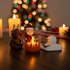 Grappige kerstdecoratie met Santa die een facepalm doet terwijl Rudolf en een smeltende sneeuwpop rond een theelicht-kampvuur zitten. Warme kerstverlichting op de achtergrond zorgt voor een knusse, feestelijke sfeer. Perfect als unieke handgemaakte kerstdecoratie of cadeau.