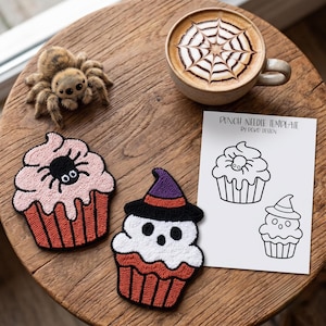 May include: Two punch needle cupcake patches, one with a spider and one with a witch hat, a fuzzy spider figurine, and a white paper punch needle template with the text PUNCH NEEDLE TEMPLATE by POKO DESIGN featuring two cupcake line drawings.