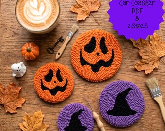 May include: Four round punch needle coasters featuring two orange pumpkin faces and two purple witch hats. A purple starburst graphic contains the text car coaster PDF & 2 SizeS. The coasters are arranged with a coffee cup, a small pumpkin, a ghost figurine, a key, two brushes, and dried autumn leaves.