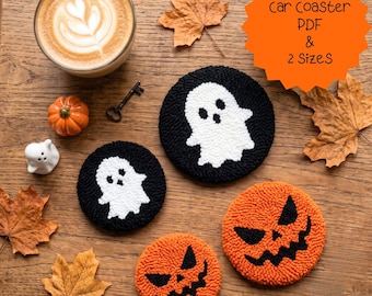 May include: Two round black coasters with white ghost designs and two round orange coasters with black jack-o'-lantern faces. The text car coaster PDF & 2 SizeS is visible. These tufted items are displayed alongside a coffee cup, a small pumpkin, a ghost figurine, a metal key, and dried autumn leaves.