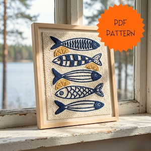 May include: A framed textile art piece featuring five stylized blue fish designs with yellow lemon slices. The artwork is set against a beige background and framed in light wood. The orange tag says "PDF PATTERN".