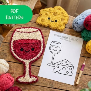 Op de afbeelding: Een handgemaakte onderzetter in de vorm van een wijnglas met rode vulling, een crèmekleurige rand en een lachend gezicht. Er is ook een gele, kaasvormige onderzetter met een lachend gezicht. De afbeelding bevat een punch needle sjabloon met een illustratie van een wijnglas en kaas.