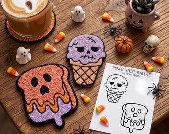 May include: Two punch needle patches featuring a purple skull ice cream cone and an orange ghost toast, accompanied by a white paper punch needle template with the text PUNCH NEEDLE TEMPLATE BY POKO DESIGN, surrounded by candy corn and small decor.