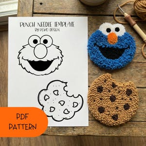 May include: A punch needle template by Poko Design with a PDF pattern. The template features a cartoon character and a cookie design. Two completed punch needle projects are shown: a blue character and a brown cookie.