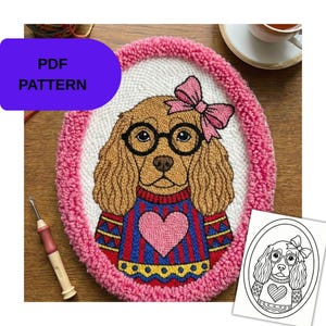 May include: Oval-shaped, handmade textile art featuring a dog wearing glasses and a bow. The dog is wearing a sweater with a heart design. The artwork is framed with a pink border and includes the text "PDF PATTERN".