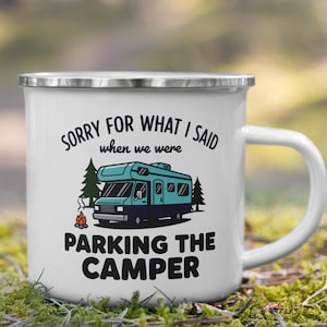 May include: White enamel camping mug with a silver rim and a white handle. The mug features the text "SORRY FOR WHAT I SAID when we were PARKING THE CAMPER" above a teal camper illustration with trees and a campfire.
