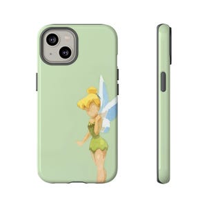 Peut inclure: Coque de téléphone vert clair avec une illustration à l'aquarelle d'une fée aux cheveux blonds, une robe verte et des ailes bleues et blanches. L'étui a un anneau de caméra argenté et des boutons latéraux noirs. La vue latérale de l'étui est également vert clair.