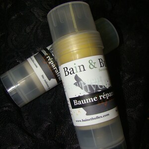 May include: Two clear plastic tubes with yellow balm inside. The label on the front of the tube reads "Bain & Bulles Savon Bleu Hydra... Baume r&eacute;parateur www.bainetbulles.com".