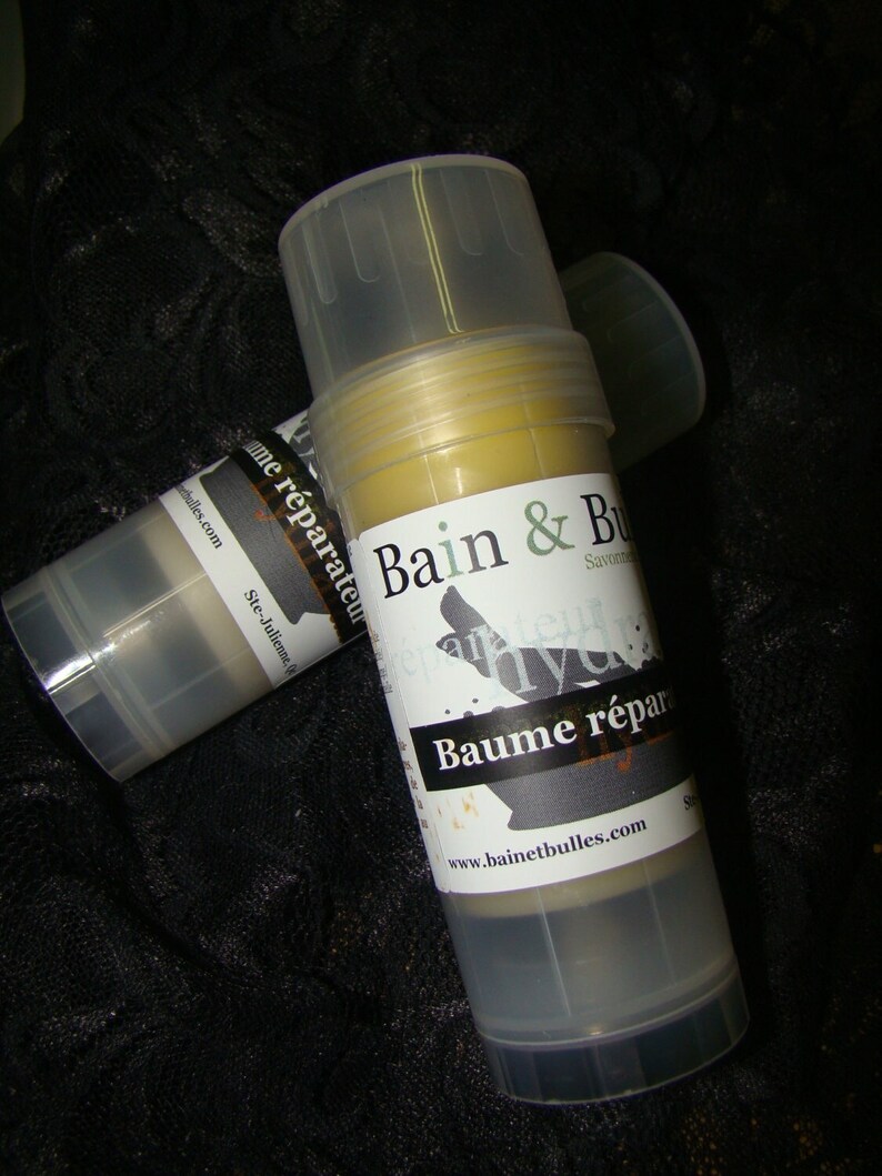 May include: Two clear plastic tubes with yellow balm inside. The label on the front of the tube reads "Bain & Bulles Savon Bleu Hydra... Baume r&eacute;parateur www.bainetbulles.com".