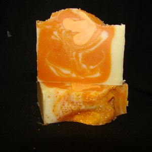 K&ouml;nnte beinhalten: Zwei St&uuml;ck orange-wei&szlig;e Marmorseife mit glitzerndem orangefarbenem Finish.