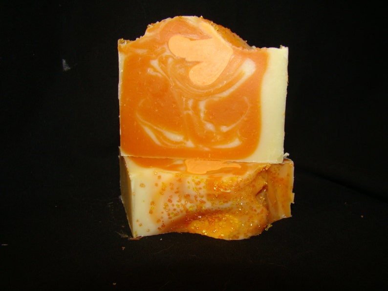 K&ouml;nnte beinhalten: Zwei St&uuml;ck orange-wei&szlig;e Marmorseife mit glitzerndem orangefarbenem Finish.