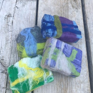 May include: Four handmade felted soap bars in various colors and patterns. The soaps are made with natural fibers and are perfect for a luxurious bath experience.