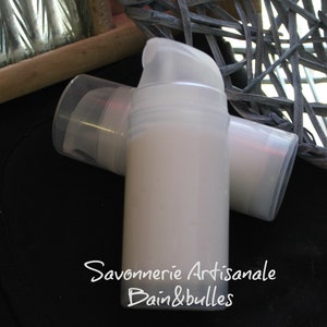 May include: Two translucent white plastic pump bottles containing a light-colored lotion. The bottles feature a clear cap and a pump dispenser. The text "Savonnerie Artisanale Bain&bulles" is printed in white on the front of the bottles.
