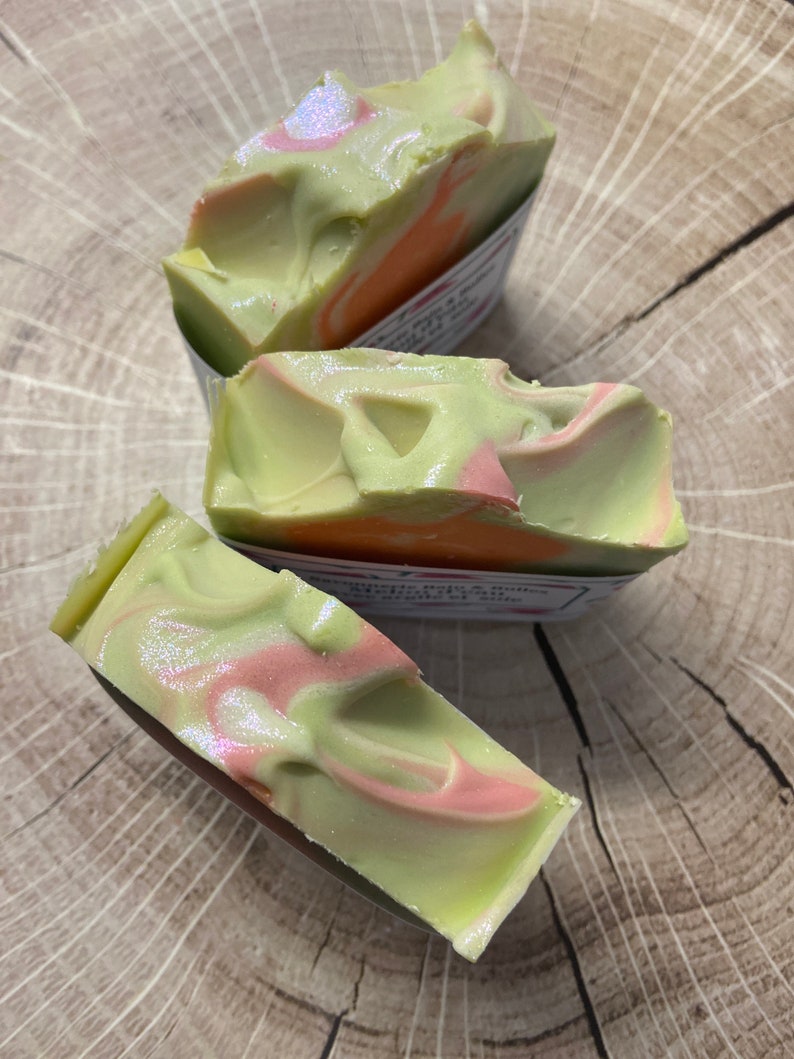 Op de afbeelding: Drie handgemaakte zeepjes met een groene en roze swirl-patroon. De zeep is gemaakt met natuurlijke ingredi&euml;nten en is perfect voor gevoelige huid.