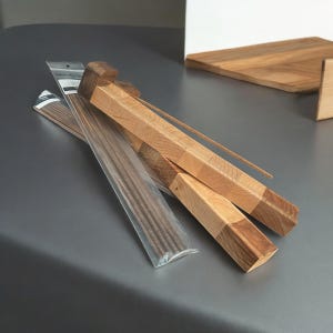 Puede incluir: Un porta incienso de madera con un acabado de madera natural. El porta incienso est&aacute; hecho de dos piezas de madera que se unen para crear un dise&ntilde;o &uacute;nico. El porta incienso est&aacute; dise&ntilde;ado para sostener varillas de incienso y es perfecto para agregar un toque de ambiente a cualquier habitaci&oacute;n.