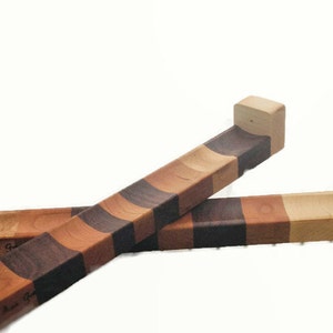 Puede incluir: Dos soportes de tabla de cortar de madera con un patr&oacute;n a rayas de madera de cerezo, arce y nogal. Los soportes est&aacute;n dise&ntilde;ados para colgar en la pared.