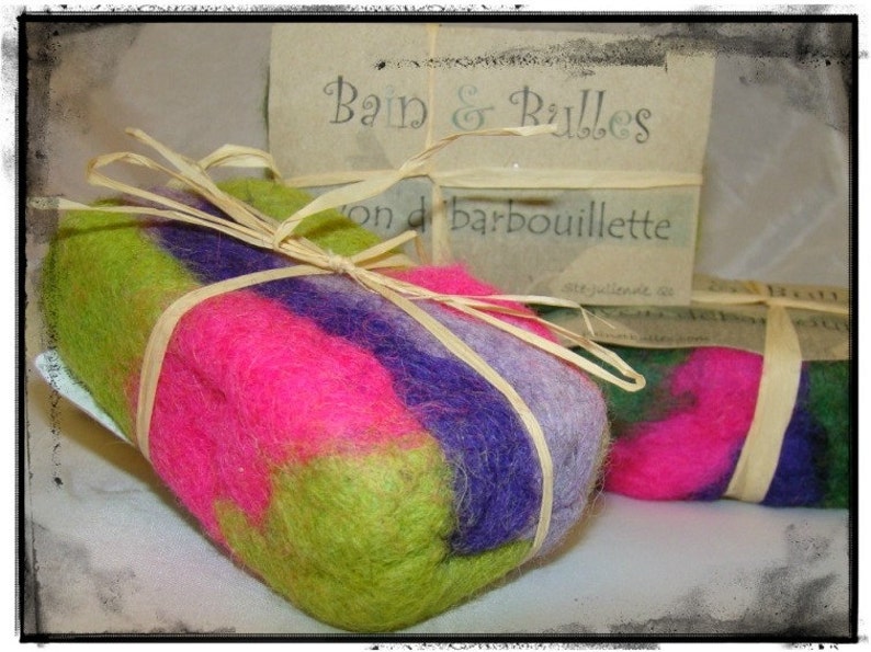 May include: Two colorful felted soap bars with green, pink, and purple stripes. The soap bars are tied with natural twine and labeled "Bain & Bulles" and "on de barboullette".