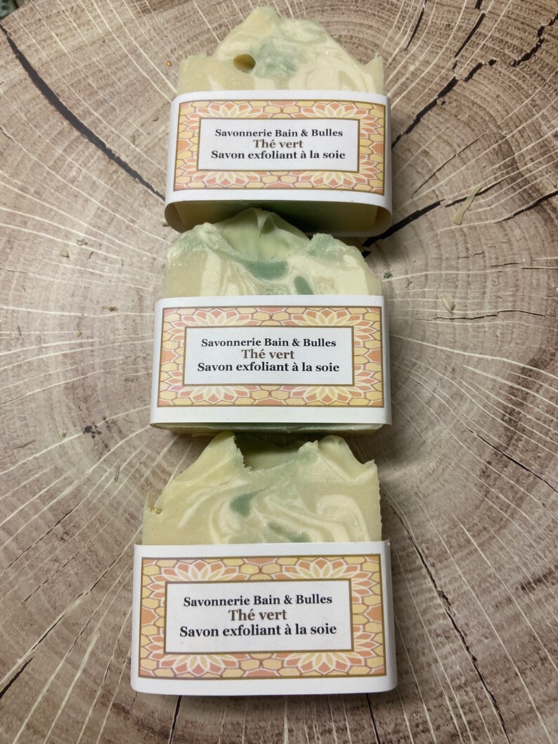 May include: Three bars of green and white soap with a label that reads "Savonnerie Bain & Bulles Th&eacute; vert Savon exfoliant &agrave; la soie".